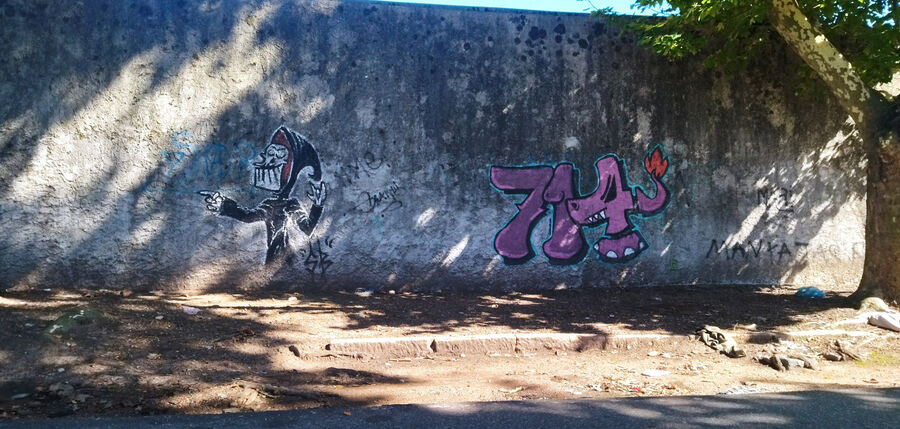 Muros que hablan 05 - Grafiti representando a la muerte dibujada estilo comic y con un 714 con tipografía urbana - muro lateral del Colegio Pio