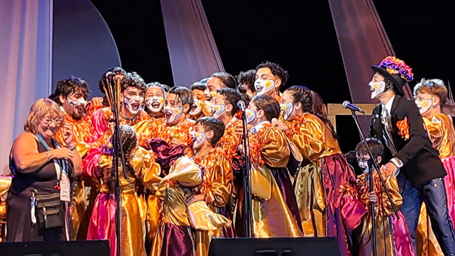 Murga La Zafada, foto del momento en que la murga, vestida con sus trajes de gala, tela de raso colores naranja, fucsia y violeta, reciben el trofeo